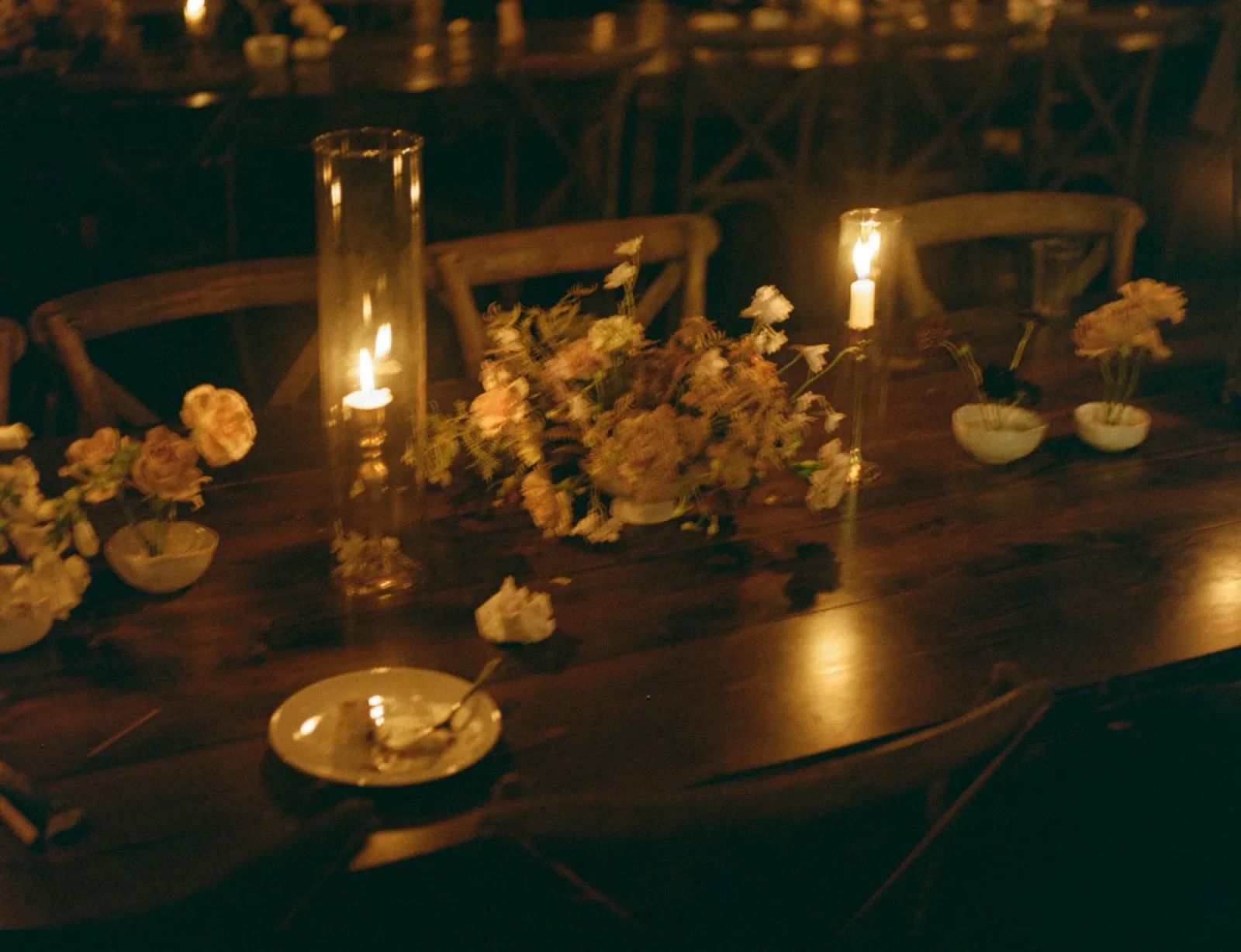 Candlelit tables at night with low amber arrangements